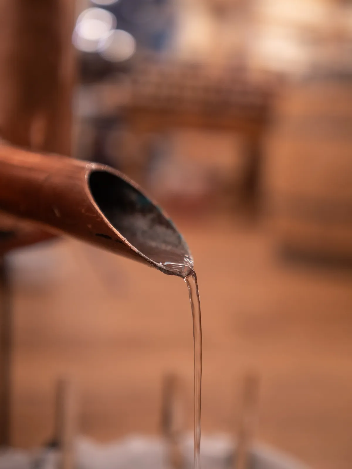 Distillat qui coule du col de cygne d’un alambic en cuivre